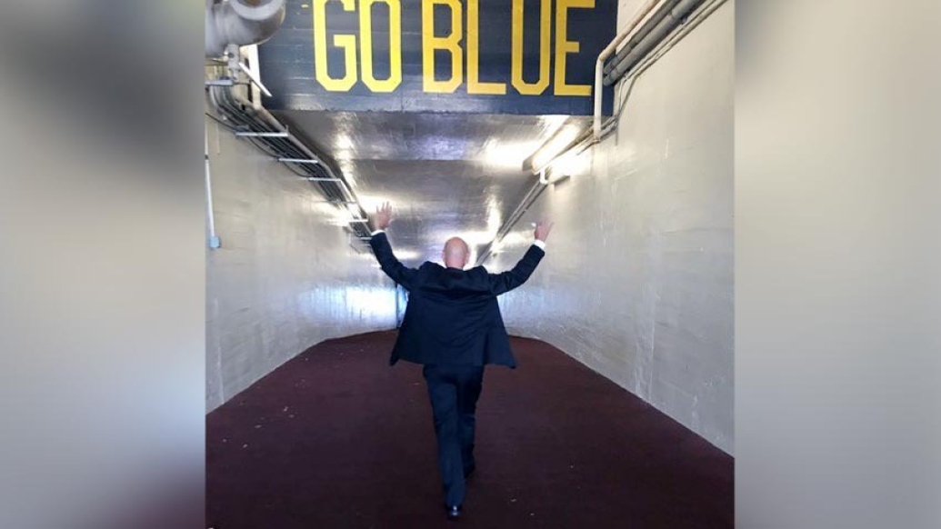 Patient walking down Go Blue tunnel with hands up in the air