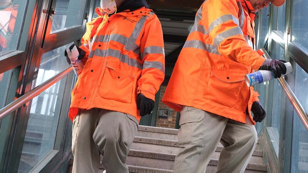 Workers spraying disinfectant on stairway