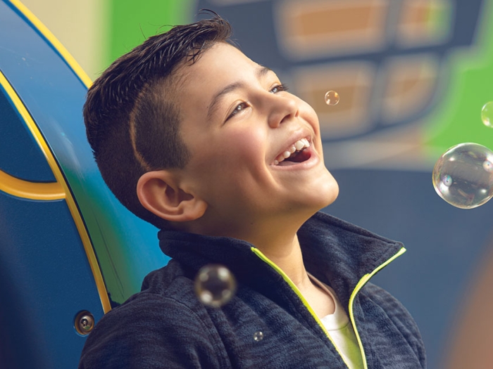 Dominic smiles while playing with bubbles