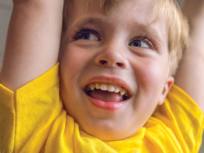 Logan raises his arms and smiles widely