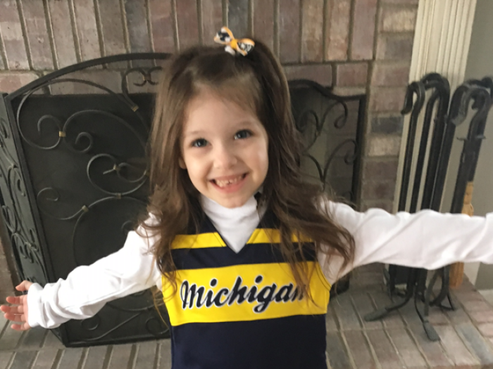 Young Blaire smiles for a photo in her Michigan outfit