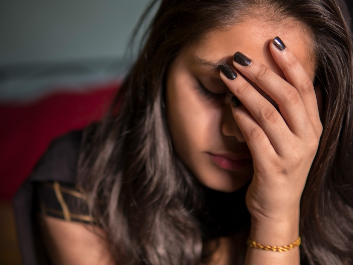 Sad young woman face in hand