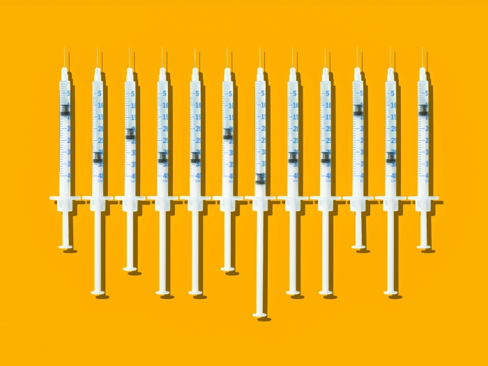 Syringes in a row on yellow backfround