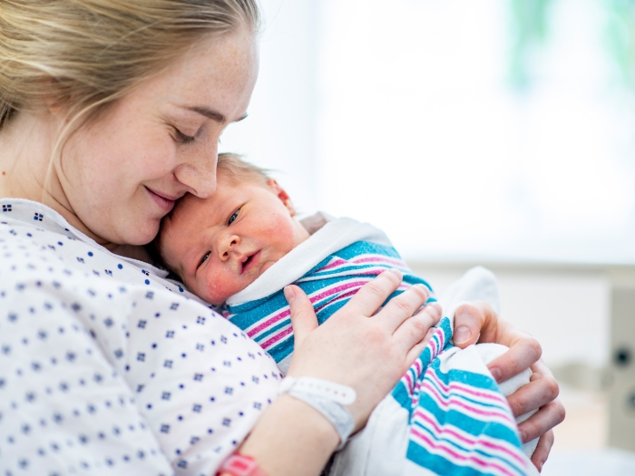 mom in hospital bed holding newborn baby