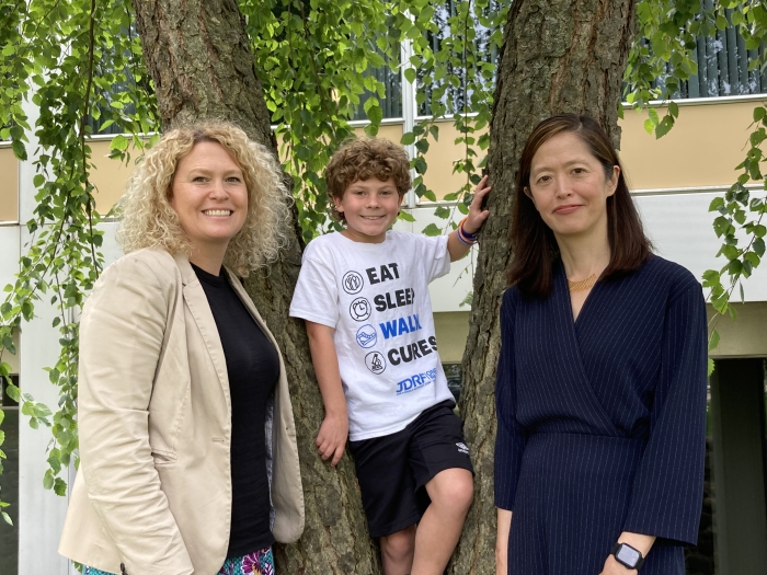 mom child and doctor smiling by tree
