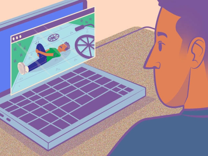 Person sitting at desk with computer on a blurred Zoom meeting