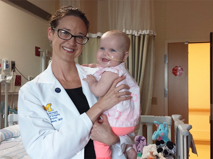 doctor holding baby smiling hospital