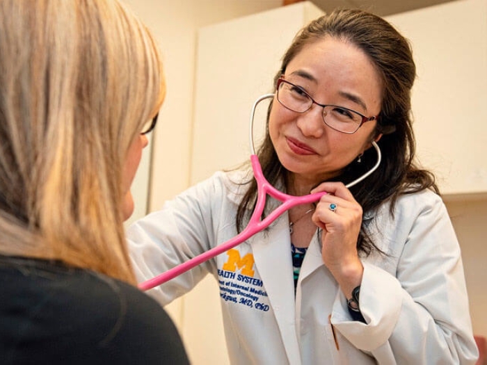 Doctor in whitecoat giving an exam with stethocope on patient