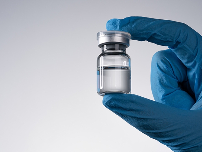 glove hand holding vaccine vial