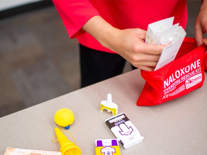 hands in red bag with medication naloxone