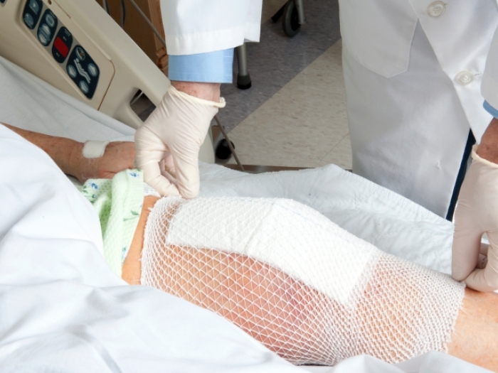 Doctor applying a bandage to a man's knee