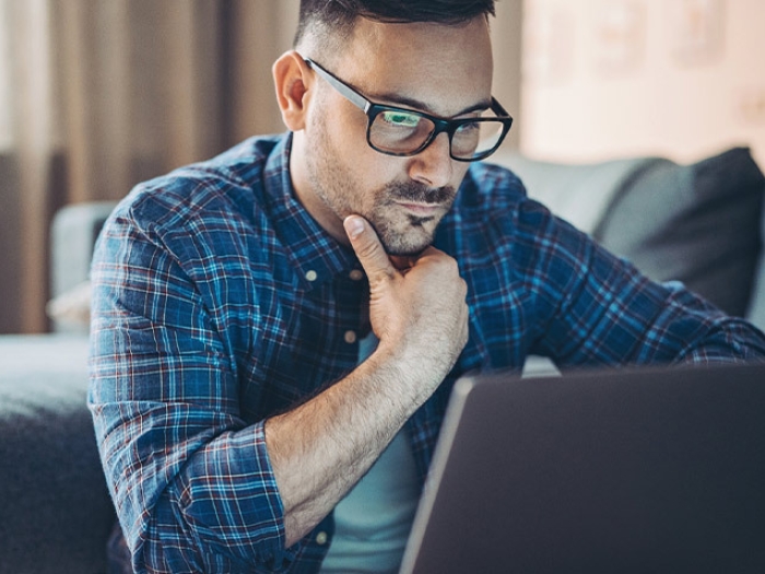 man worried looking at laptop