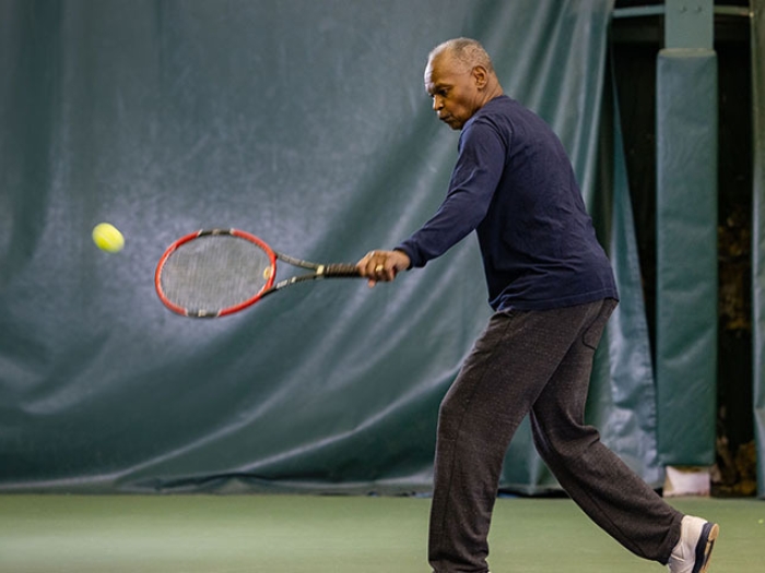 man hatting tennis ball