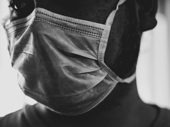 mask on man in gray black and white photo close up to face
