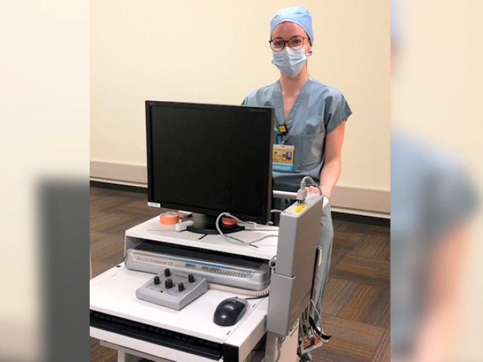 medical professional in scrubs at cart montior