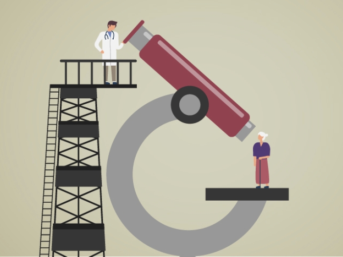 Doctor looking down at patient from above through a large, red microscope