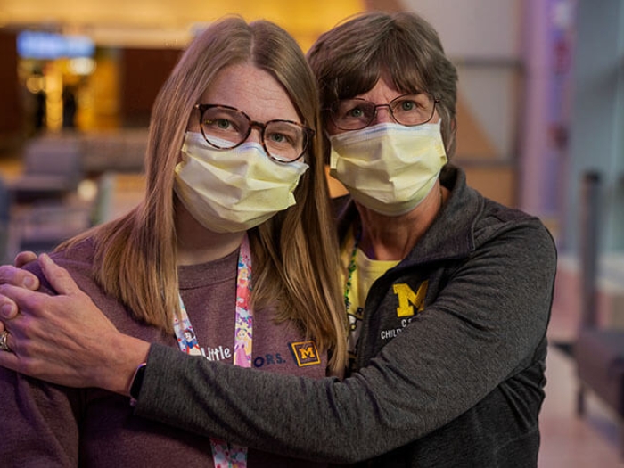 Mother and daughter nurses hugging in room at Mott.