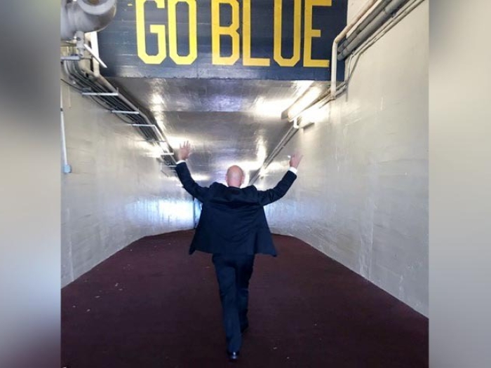 Patient walking down Go Blue tunnel with hands up in the air