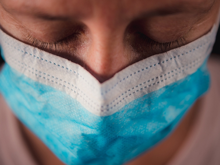 person wearing blue and white mask close up