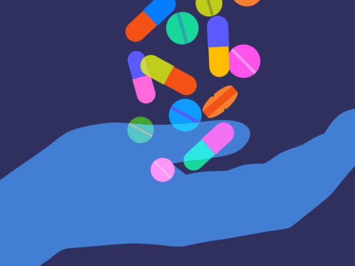 colorful pills falling into blue hand