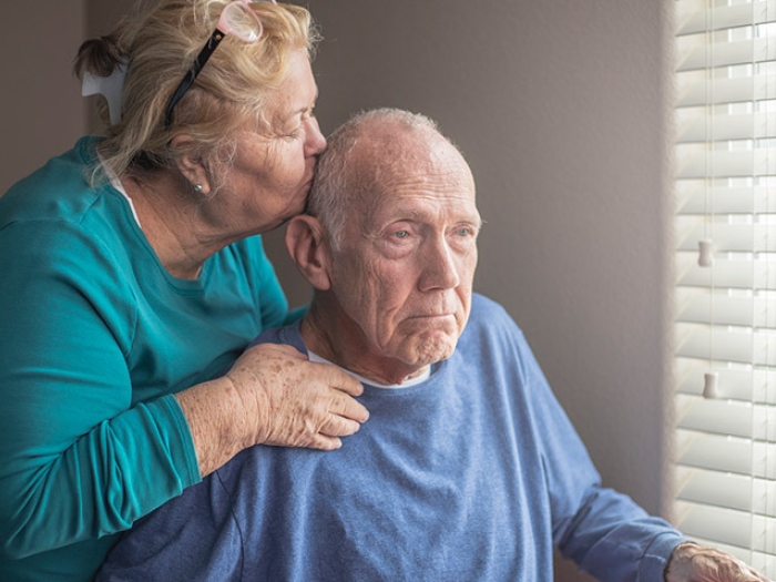 senior couple kiss forehead window