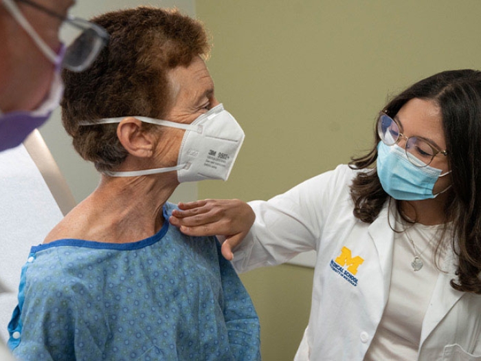 Providers looking over patient wearing masks