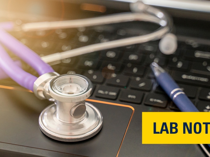 stethoscope black laptop keyboard pen with light in left corner