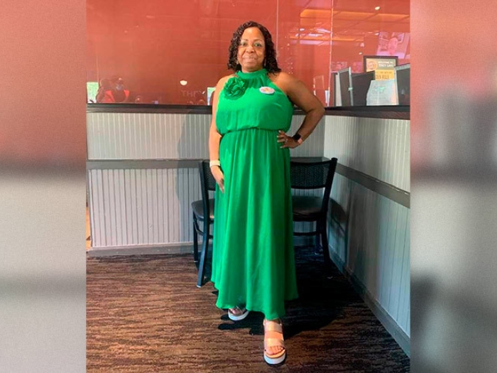 woman standing posing in green silk formal dress