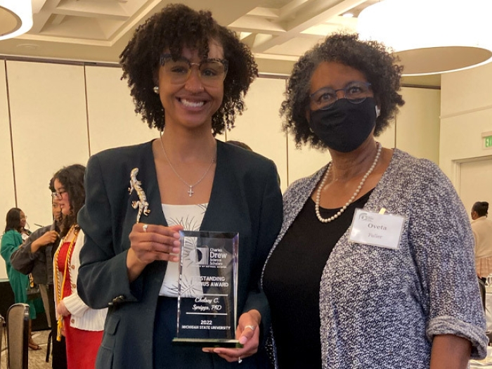 women smiling holding award conference 