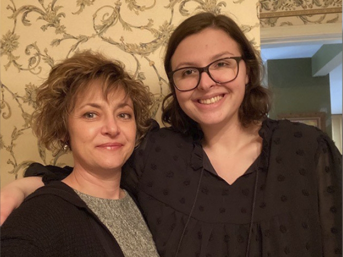 mother and daughter standing smiling at camera together