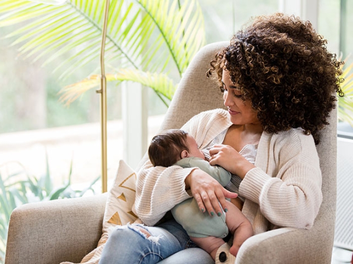 Women holding newborn in rocking chair