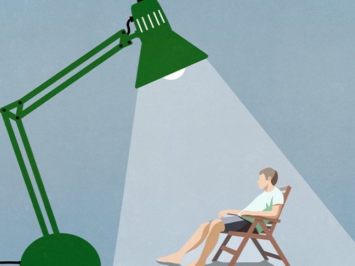 cartoon man under spotlight of green lamp sitting in chair