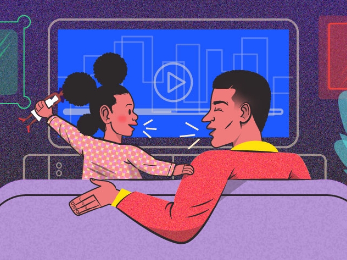 Child sitting with parent on couch socializing while watching show