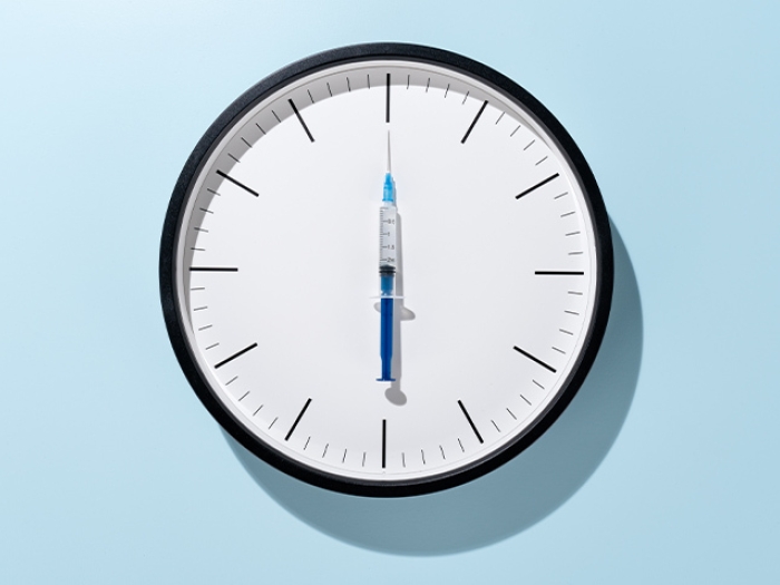 clock with vaccine as clock hand