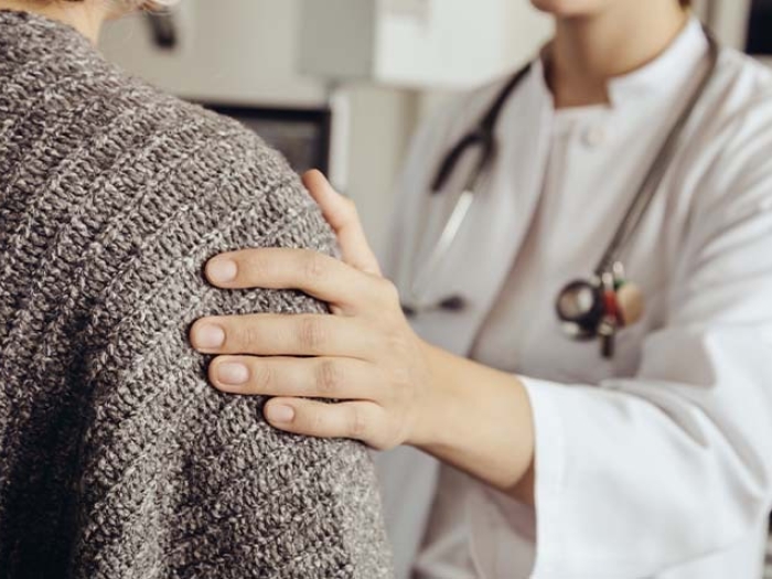 doctor's hand on patient's shoulder