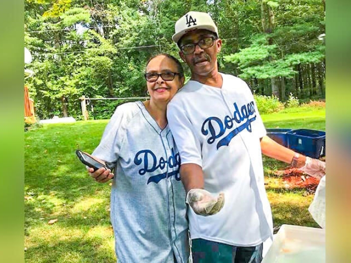Husband and wife cooking out with their baseball shirts on