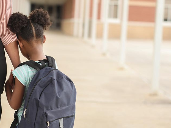 Back of little girl with mother holding her hand