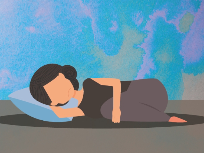 woman laying on floor on pillow holding stomach sad