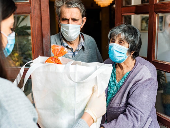 person delivering forceries to elderly couple