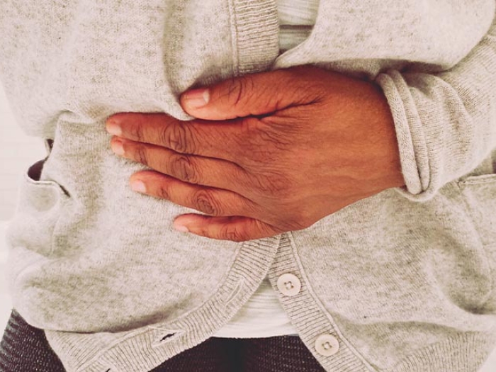 person holding stomach in pain