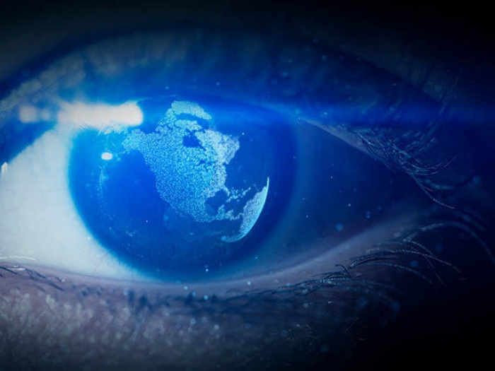 Pupil of eye with world map being reflected in the eye