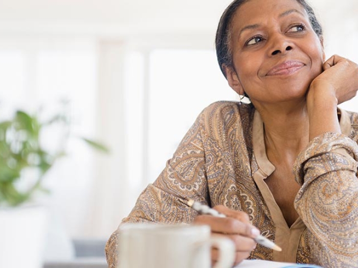 Woman staring in distance with a pencil in hand