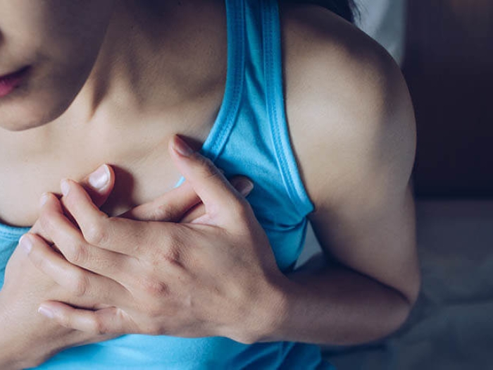 Young women holding her chest near heart