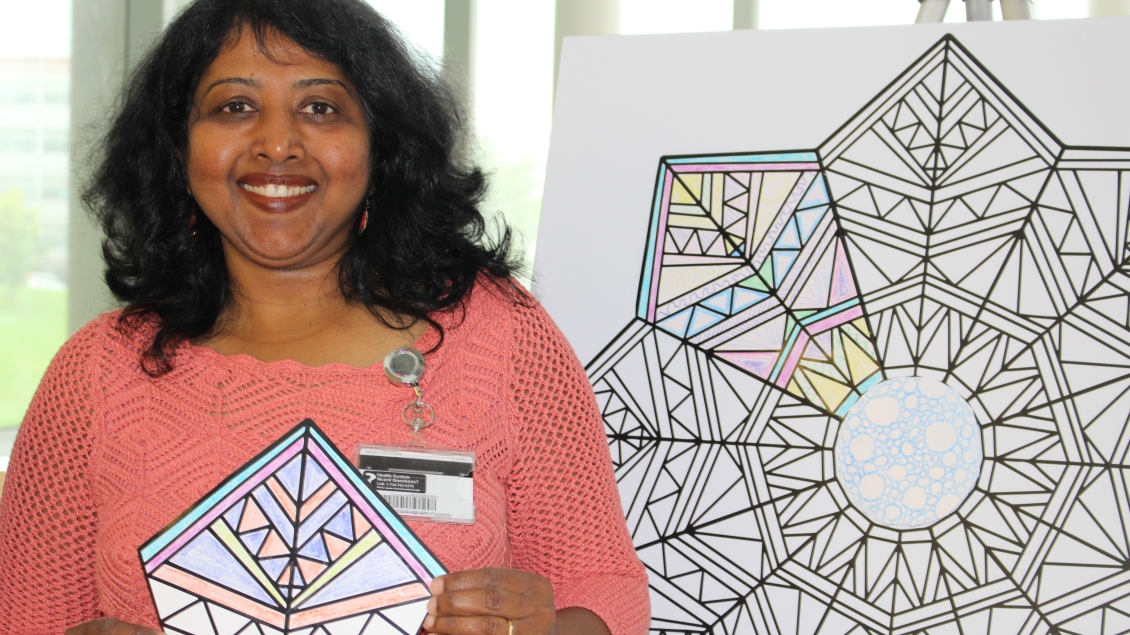 A volunteer holds up a completed coloring sheet