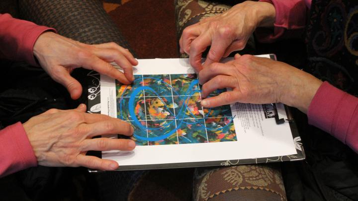 Two sets of hands working on an art project together