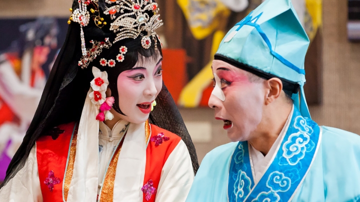 Artists with painted face looking at each other.